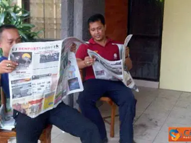 Citizen6, Bali: Pada Minggu, 10 April 2011 di Jalan PB Sudirman, Kampus Udayana. Yudiartwan (24) dan Komang Jaunuadi (37) mengisi waktu di sela-sela waktu kerja dengan membaca koran, agar tidak bosan dan juga menambah informasi. (Pengirim: Kelompok 11) 