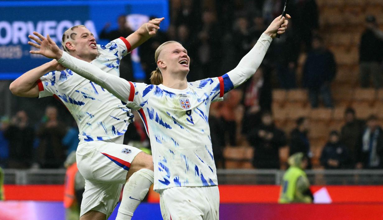 Di pertandingan terakhir Grup I Kualifikasi Piala Dunia 2026 zona Eropa melawan Italia, Haaland sukses mencetak dua gol dalam kurun waktu dua menit. Tampak dalam foto, kapten Timnas Norwegia, Erling Braut Haaland merayakan kemenangan bersama rekan setimnya, Julian Ryerson, setelah memenangkan pertandingan kualifikasi Piala Dunia 2026 zona Eropa antara Italia dan Norwegia di Stadion San Siro, Milan, pada 16 November 2025. (Alberto PIZZOLI/AFP)