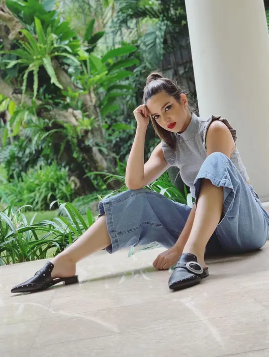 Nia Ramadhani memilih memadukan kulot jeans dengan halter neck berwarna abu-abu berdetail ruffle di bagian lengan. Untuk melengkapi penampilan kasualnya, ia mengenakan mules hitam. Yang mencolok justru terlihat pada makeup dan tatanan rambutnya (instagram/ramadhaniabakrie)