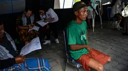 Seorang pria menunggu petugas melakukan pengukuran dan pencetakan kaki palsu di kantor Dinas Sosial Aceh, Senin (16/9/2019). Untuk tahun 2019 ini diberikan secara gratis sebanyak 100 kaki dan tangan palsu untuk para penyandang disabilitas di sejumlah kabupaten/kota. (CHAIDEER MAHYUDDIN / AFP)