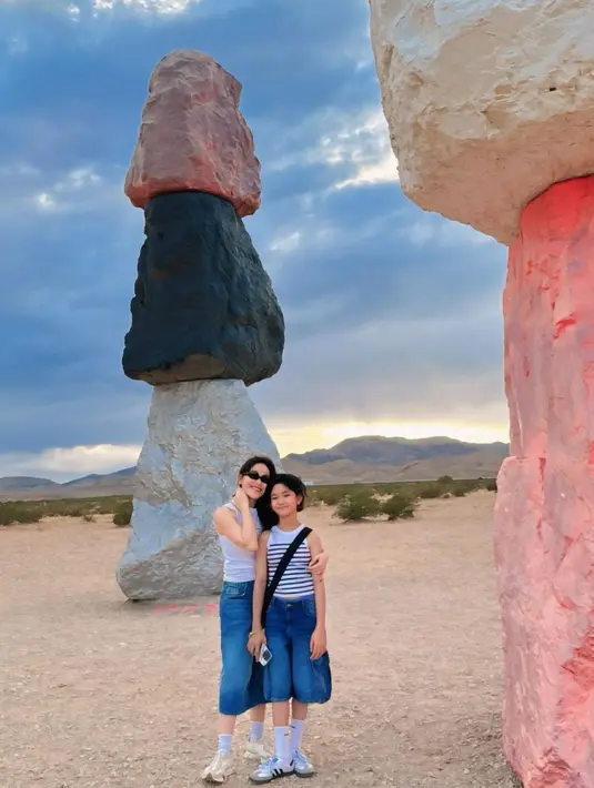 Bak kakak-adik, Ayu Ting Ting bergaya kembar Bersama sang putri. Ayu dan Bilqis sama-sama mengenakan tank top putih dan midi denim pants, kaus kaki putih yang tinggi, dan sneakers putih yang serasi. [Foto: Instagram/ayutingting92]