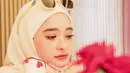 Inara Rusli pilih tampil manis kenakan sweater putih dengan monogram hati warna pink. Dipadukan dengan hijab dan kacamata putih. [@iinararusli_]
