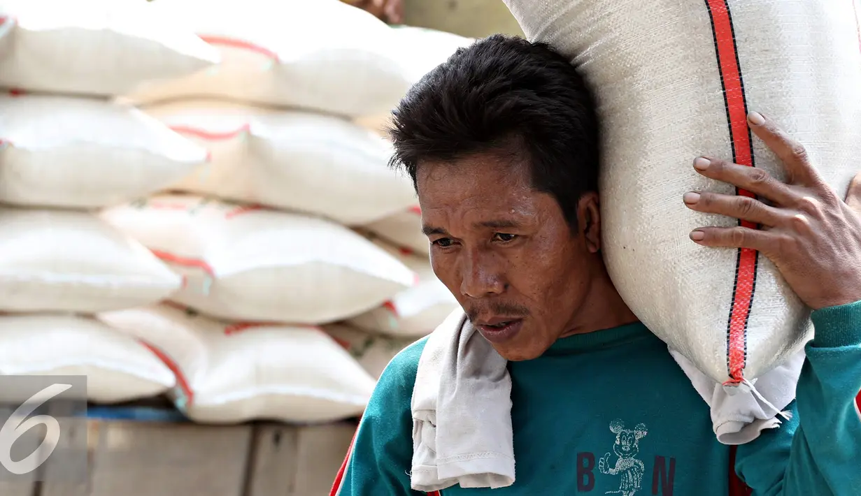 Pekerja memikul beras di Pasar Induk Beras Cipinang, Jakarta, Selasa (11/10). Menko Perekonomian Darmin Nasution memprediksi persediaan beras hingga akhir tahun akan mencukupi menyusul musim hujan di beberapa daerah. (Liputan6.com/Immanuel Antonius)