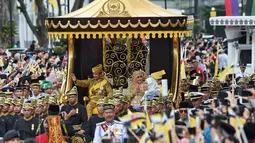 Sultan Hassanal Bolkiah dan Ratu Saleha Brunei saat naik kereta kerajaan melambaikan tangan kepada warga sekitar selama prosesi Golden Jubilee di Bandar Seri Begawan (5/10). Perayaan tersebut menandai 50 tahun bertahta. (AFP PHOTO / Roslan Rahman)