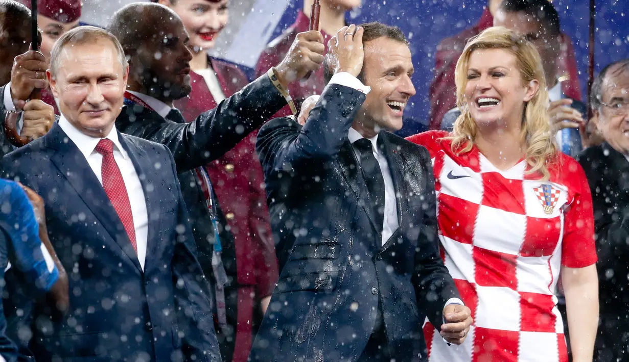 Senyum Presiden Rusia Vladimir Putin (kiri) bersama Presiden Prancis Emmanuel Macron (tengah) dan Presiden Kroasia Kolinda Grabar-Kitarovic usai laga final Piala Dunia 2018 di Stadion Luzhnik, Moskow, Rusia, Minggu (15/7). (AP Photo/Petr David Josek)