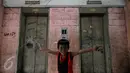 Seorang anak berpose di depan lift yang tidak berfungsi lagi di Rusun Tanah Abang, Jakarta, Senin (4/1/2016). Tahun 2016 Pemprov DKI Jakarta akan membangun 50 rusun bagi warga yang terkena dampak program normalisasi sungai  (Liputan6.com/Johan Tallo)