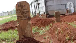 Foto aerial makam dengan nisan satire bertuliskan Indonesia Bin Terserah Kalian di TPU Jombang, Tangerang Selatan, Rabu (27/5/2020). Tulisan satire tersebut menyindir masyarakat yang tidak mematuhi aturan selama pemberlakuan Pembatasan Sosial Berskala Besar (PSBB). (Liputan6.com/Helmi Fithriansyah)