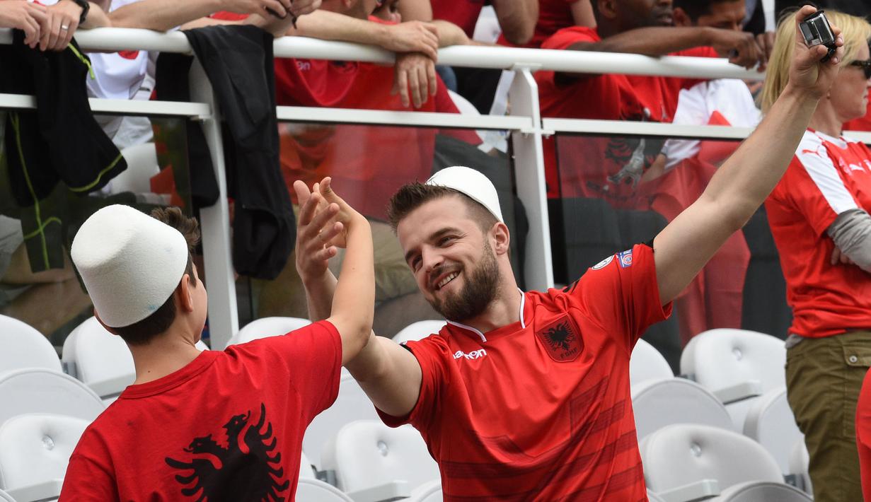 Suporter Albania melakukan selfie sambil menari saat menonton laga grup A Euro Cup 2016 antara Albania melawan Swiss di Stadion Bollaert-Delelis, Lens (11/6/2016). (AFP/Francois Lo Presti)