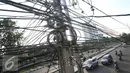 Instalasi kabel saling bersinggungan di tiang Jalan Gunung Sahari, Jakarta, Rabu (13/7). Kurangnya penataan membuat instalasi kabel di Ibu Kota terlihat semrawut dan mengganggu pemandangan. (Liputan6.com/Immanuel Antonius)