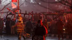 Polisi Afghanistan berjaga-jaga di dekat bangkai minibus yang meledak di dekat Kedubes Rusia di Kabul, Rabu (20/1). Ledakan itu menimbulkan asap hitam, sementara ambulans dan mobil pemadam kebakaran segera dikerahkan ke lokasi. (REUTERS/Ahmad Masood)