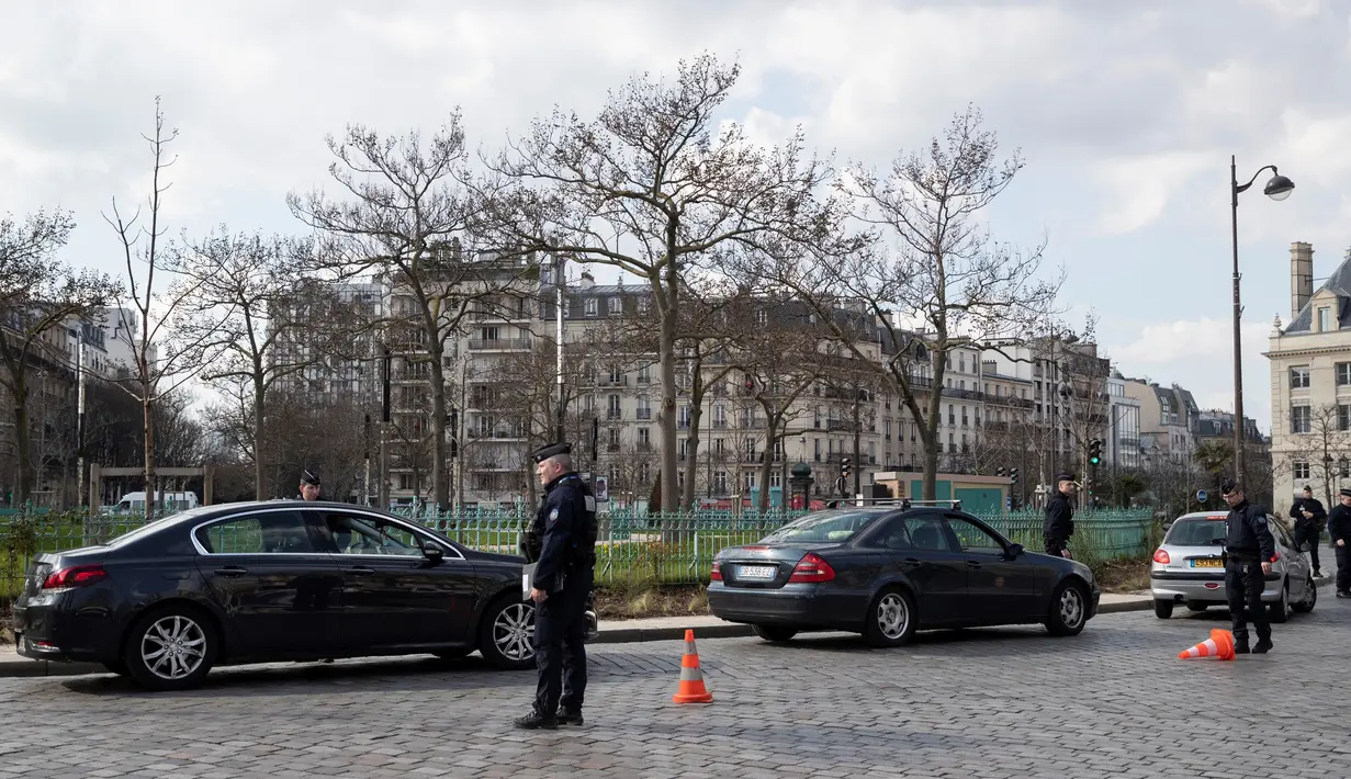Polisi menghentikan kendaraan untuk memeriksa dokumen pengemudi saat lockdown di Place d'Italie, Paris, Prancis, Rabu (18/3/2020). Presiden Prancis Emmanuel Macron memerintahkan pembatasan ketat pada pergerakan warga di tengah pandemi virus corona COVID-19 yang terus memburuk. (Thomas SAMSON/AFP)