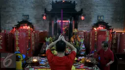 Seorang Umat Tionghoa Bersembahyang dan berdoa di klenteng Vihara Amurva Bhumi, Setiabudi, Jakarta Selatan, Minggu, (7/2/2016). Banjir yang melanda vihara ini di akibatkan luapan kali Krukut. (Liputan6.com/JohanTallo)