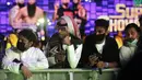 Penggemar gulat mengenakan masker ketika mereka menonton pertandingan gulat WWE Super ShowDown di Riyadh, Arab Saudi, Kamis (27/2/2020). Pemerintah Arab Saudi pada hari Kamis, 27 Februari 2020 resmi menghentikan sementara izin umrah bagi seluruh negara. (AP Photo/Amr Nabil)