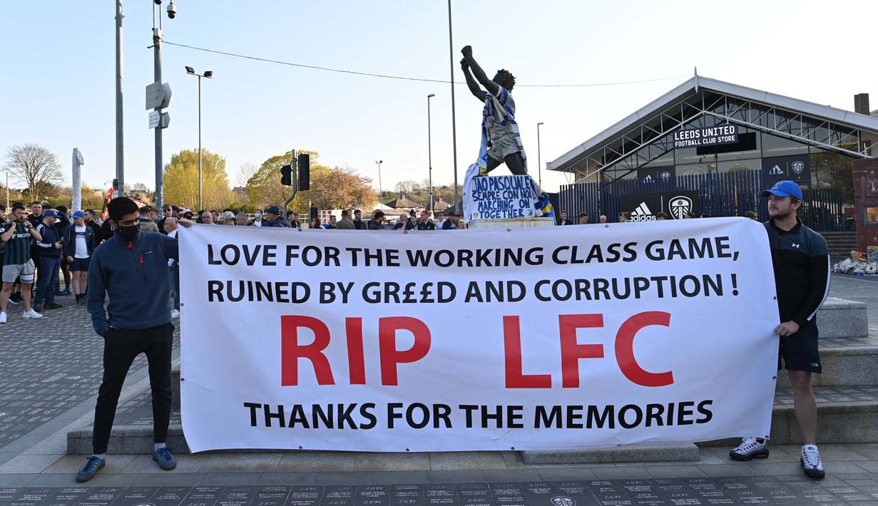 Penggemar Leeds United memegang spanduk yang menentang rencana Liga Super Eropa dan keterlibatan klub sepak bola Liverpool di luar Elland Road menjelang pertandingan sepak bola Liga Utama Inggris antara Leeds United dan Liverpool di Leeds, Senin (19/4/2021). (Foto: AFP/Paul Ellis)