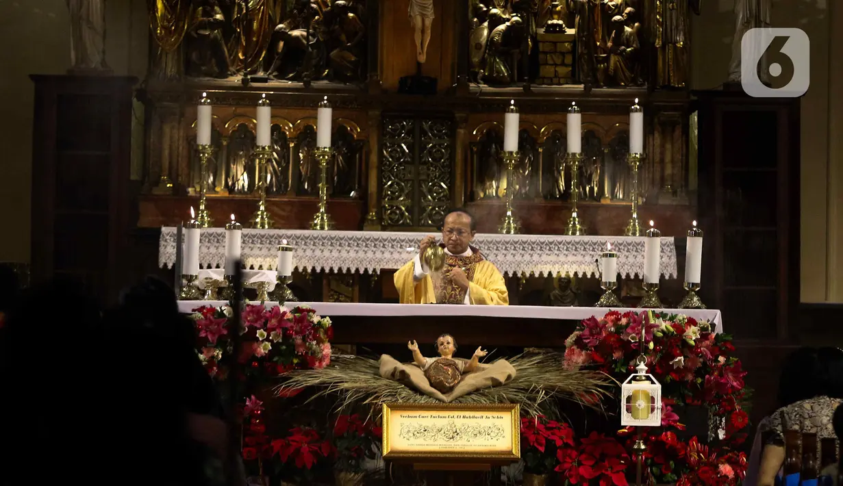Umat Katolik melaksanakan Misa Malam Natal di Gereja Katedral, Jakarta, Minggu (24/12/2023). Tema Natal yang diusung Gereja Katedral Jakarta tahun ini adalah 'Kemuliaan kepada Allah dan Damai Sejahtera di Bumi'. (Liputan6.com/Herman Zakharia)