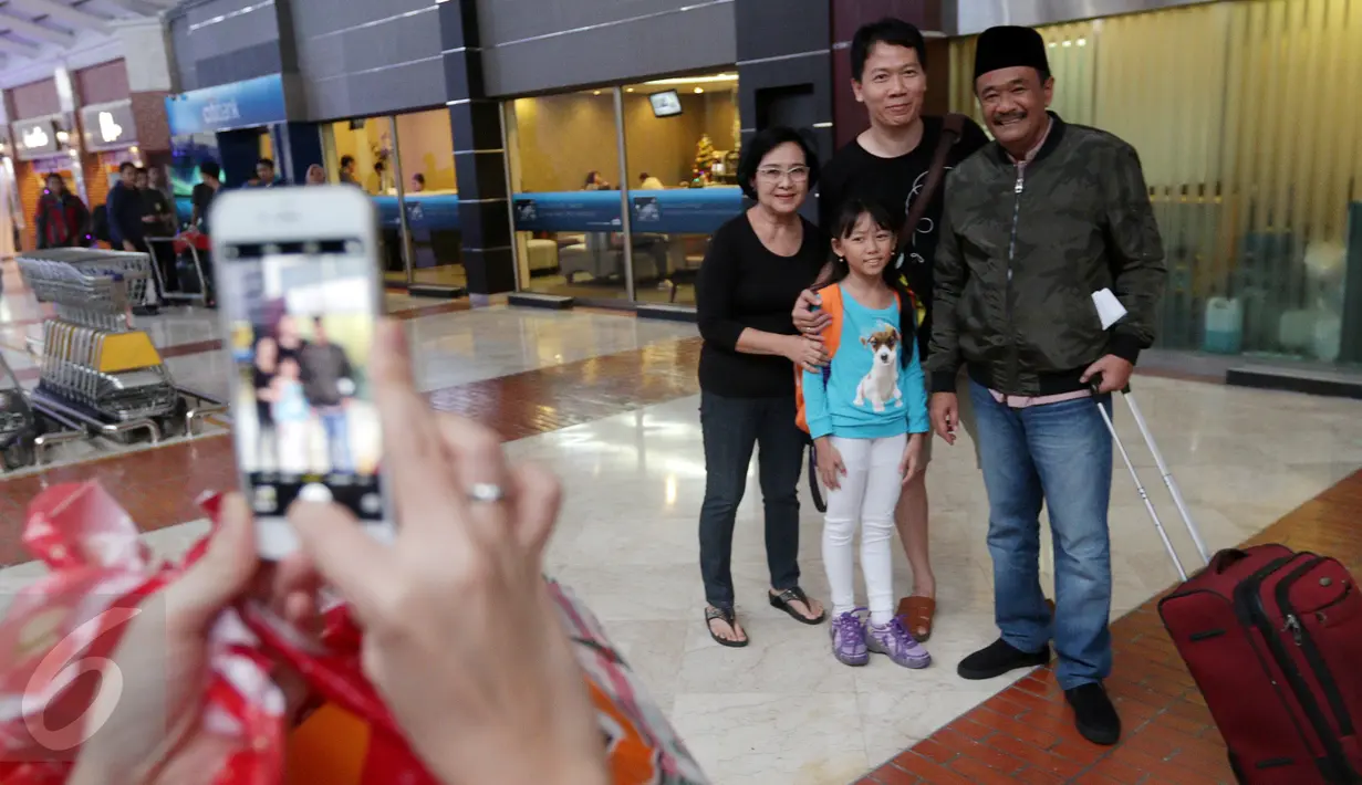 Cawagub DKI Jakarta, Djarot Saiful Hidayat foto bersama dengan keluarga calon penumpang di Terminal 2E Bandara Soetta, Tangerang Minggu (25/12). Tujuan umroh untuk memanjatkan doa agar Jakarta semakin aman dan toleran. (Liputan6.com/Fery Pradolo)