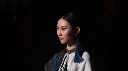 Seorang model memeragakan kreasi busana yang terbuat dari brokat Li, pakaian tradisional yang dibuat oleh kelompok etnis Li, dalam sebuah peragaan busana di Haikou, Provinsi Hainan, China selatan, pada 19 November 2020. (Xinhua/Guo Cheng)