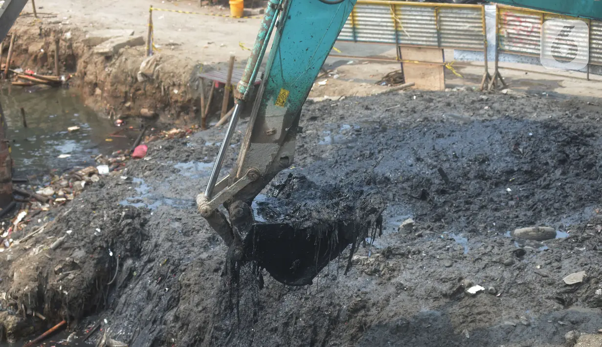 Alat berat mengangkat material endapan lumpur di Kampung Nelayan Cilincing, Jakarta Utara, Kamis (2/9/2021). Pengerukan dilakukan untuk mengurangi pendangkalan di muara teluk Jakarta serta penataan sandaran kapal-kapal tradisional. (merdeka.com/Imam Buhori)