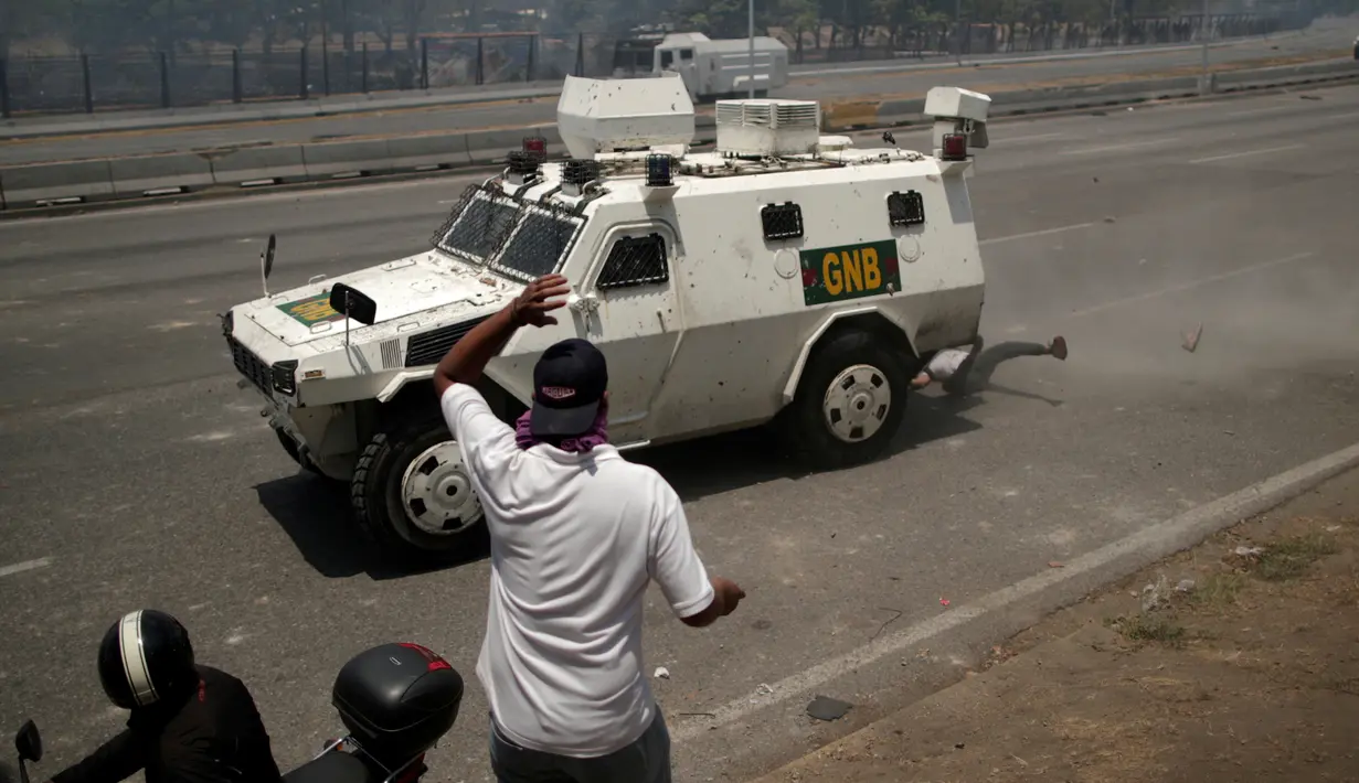 Pengunjuk rasa pendukung oposisi, Luis Alejandro saat ditabrak kendaraan taktis Garda Nasional Venezuela di luar pangkalan militer 'La Carlota' di Caracas, Venezuela (30/4/2019). (Reuters/Ueslei Marcelino)