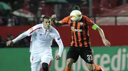 Gelandang Sevilla, Sebastian Cristoforo (kiri) berusaha menghadang pemain Shakhtar Donetsk, Darijo Srna pada leg kedua semifinal Liga Europa di Stadion Ramon Sanchez Pizjuan, Sevilla, Jumat (6/5/2016) dini hari WIB. (AFP/Cristina Quicler)