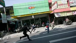 Aksi kejar-kejaran petugas kepolisian dengan sejumlah warga Papua yang melakukan demonstrasi di depan Asrama Mahasiswa Papua di Yogyakarta, Jumat (15/7). Mereka menggelar aksi menuntut kemerdekaan Papua. (Liputan6.com/Boy Harjanto)