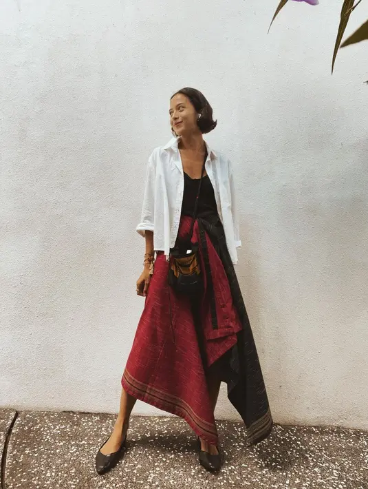 Penampilan semi formal yang manis ala Putri Marino ini juga bisa dicontoh. Ia tampak memadukan tank top hitam polos yang dilapisinya dengan kemeja putih polos dengan kancing terbuka, dan kain merah bercorak garis di bagian ujungnya. Foto: Instagram.