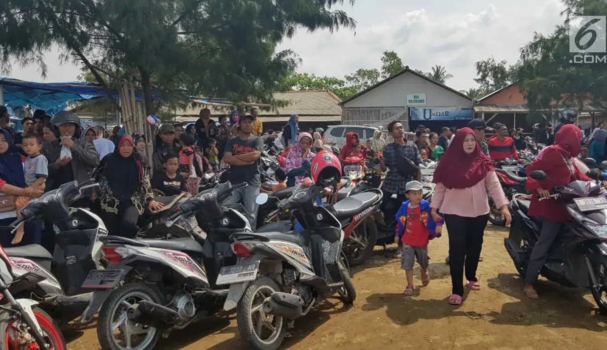 Warga berkerumun menantikan evakuasi pesawat Lion Air JT 610 di Pantai Pakis Jaya, Karawang, Jawa Barat, Senin (29/10). Lokasi jatuhnya pesawat Lion Air JT 610 tak jauh dari Pantai Pakis Jaya. (Liputan6.com/Herman Zakharia)