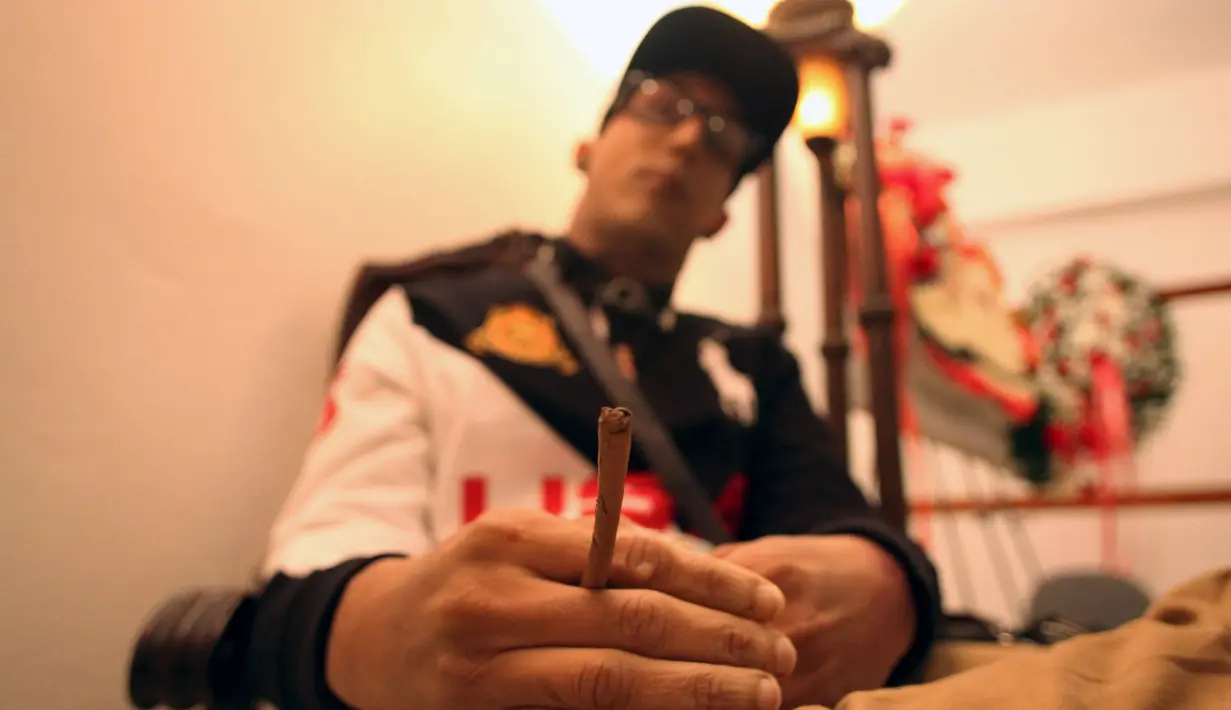 Mayat Fernando de Jesus memegang rokok di rumah duka,San Juan, Puerto Rico (11/3). Fernando tewas setelah ditembak oleh orang tak dikenal dan mayatnya diawekan oleh keluarganya. (REUTERS / Alvin Baez)