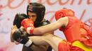 Atlet Wushu Asal Mesir, Aymen Mohamed (kiri) mendapat pukulan  Atlet Rusia, Ali  pada Cabang Sanda Kejuaraan Dunia Wushu 2015 di Istora, Senayan, Jakarta,Rabu (18/11/2015). (Bola.com/Nicklas Hanoatubun)