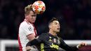 Striker Juventus, Cristiano Ronaldo, duel udara dengan bek Ajax Amsterdam, Matthijs de Ligt, pada laga Liga Champions di Stadion Johan Cruyff, Rabu (10/4). Kedua tim bermain imbang 1-1. (AP/Martin Meissner)