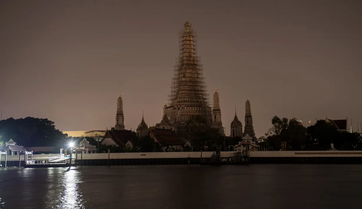 Kuil Wat Arun terlihat padam tanpa lampu penerangan saat peringatan Earth Hour Internasional di Bangkok, Thailand (25/3). Tahun ini gerakan Earth Hour melibatkan pemadaman listrik selama satu jam di 7.000 kota di 172 negara. (AFP/Roberto Schmidt)