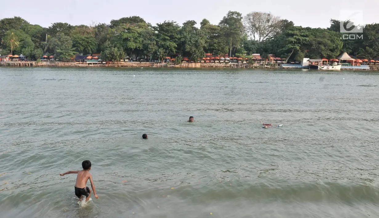 Anak-anak berenang di Danau Sunter, Jakarta, Selasa (23/7/2019). Minimnya fasilitas bermain yang layak dan murah membuat anak-anak nekat berenang di Danau Sunter. (merdeka.com/Iqbal Nugroho)