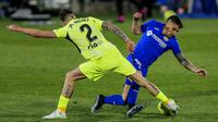 Pemain Atletico Madrid, Jose Gimenez, berebut bola dengan pemain Getafe, Mauro Arambarri, pada laga Liga Champions di Stadion Alfonso Perez, Sabtu (13/3/2021). Kedua tim bermain imbang 0-0. (AP/Manu Fernandez)
