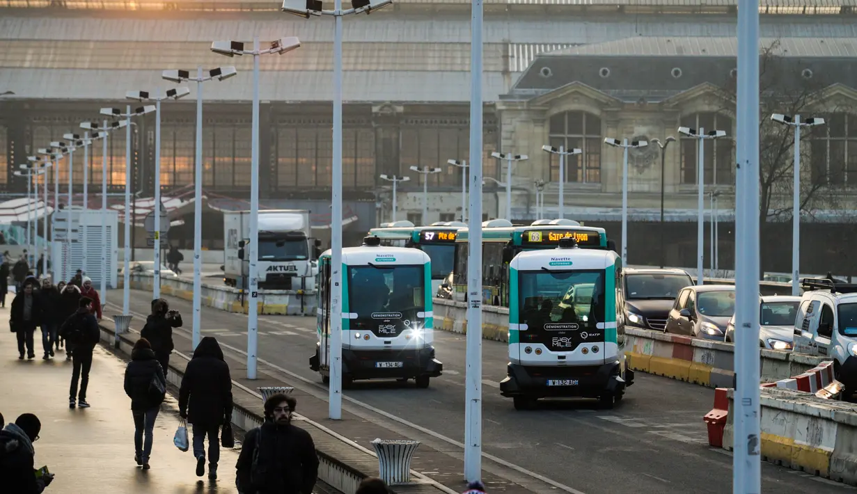 Dua bus tanpa supir (driverless) yang mulai dioperasikan di Paris, Senin (23/1). Bus listrik berbentuk kotak tersebut dilengkapi dengan laser dan kamera untuk mendeteksi objek lain dan orang di sekitarnya. (GEOFFROY VAN DER HASSELT/AFP)