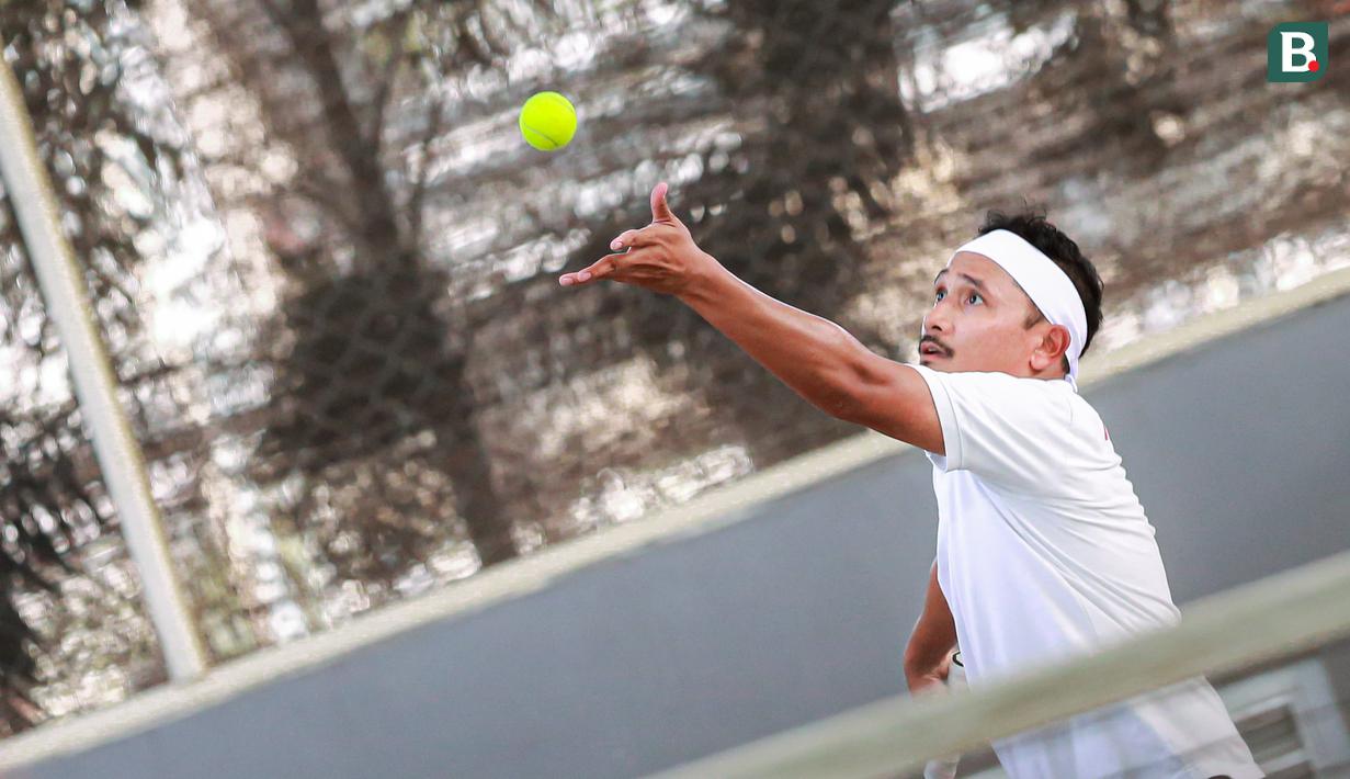 Selebritas Indonesia, Tanta Ginting melakukan servis ke arah pasangan Raffi Ahmad dan Deddy Mahendra Desta pada laga tenis nomor ganda putra Turnamen Olahraga Selebriti Indonesia di GOR UNJ, Jakarta, Minggu (30/07/2023). Tanta yang berpasangan dengan Rezky Aditya kalah dengan skor 6-4, 4-6, dan 4-6. (Bola.com/Bagaskara Lazuardi)