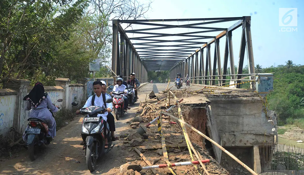 Pengendara motor melintasi jembatan Cipamingkis Cibarusah, Kab Bekasi, Jawa Barat (15/7). Jembatan tersebut merupakan penghubung dengan tiga Desa Sirnajati, Ridogalih, dan Ridomanah dengan kawasan Jonggol, Bekasi dan Cileungsi. (Merdeka.com/Arie Basuki)