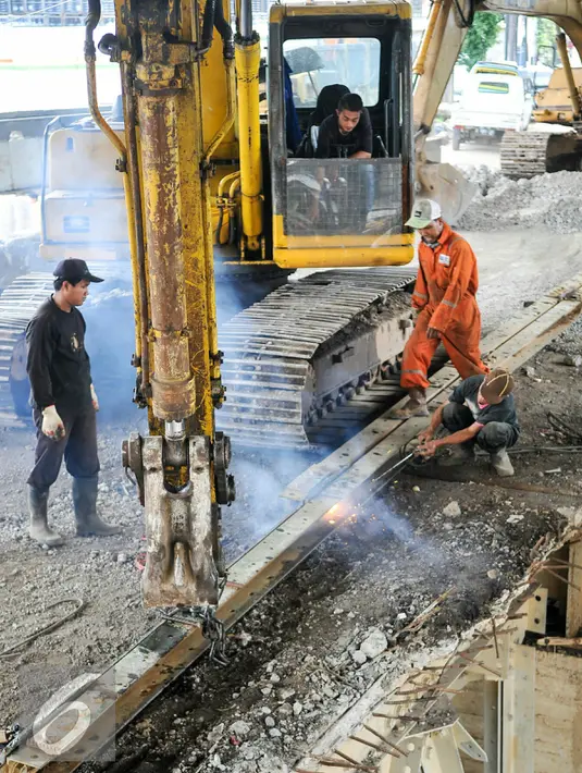 Petugas mengelas besi pondasi jembatan Rawajati untuk mempermudah pembongkaran, Jakarta, Selasa (15/3). Proses pembongkaran jembatan Rawajati telah mencapai 60 persen, dan diperkirakan akan selesai 7 hari kedepan. (Liputan6.com/Yoppy Renato)