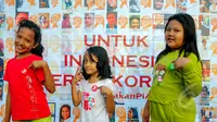 Anak kecil berpose sambil menunjukan pin bertuliskan 'Saya Anak Jujur' yang diberikan usai membubuhkan cap tangan sebagai bentuk dukungan kepada Perempuan Anti Korupsi di Bundaran HI, Jakarta, Minggu (8/3/2015). (Liputan6.com/Yoppy Renato)