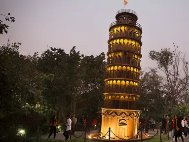 Pengunjung mengamati replika Menara Pisa di sebuah taman umum di New Delhi, 4 Februari 2020. Barang-barang bekas seperti besi batangan, suku cadang mobil, dan pipa dimanfaatkan untuk membuat tujuh keajaiban dunia yang ikonis di taman umum itu yang sukses menarik banyak pengunjung. (Xinhua/Javed Dar)