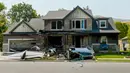 Kondisi sebuah rumah yang sengaja ditabrak oleh pesawat kecil di Payson, Utah, AS, Senin (13/8). Pesawat berwarna putih itu hangus terbakar dan hancur di halaman rumah, dekat sebuah mobil yang terguling. (Leah Hogsten/The Salt Lake Tribune via AP)