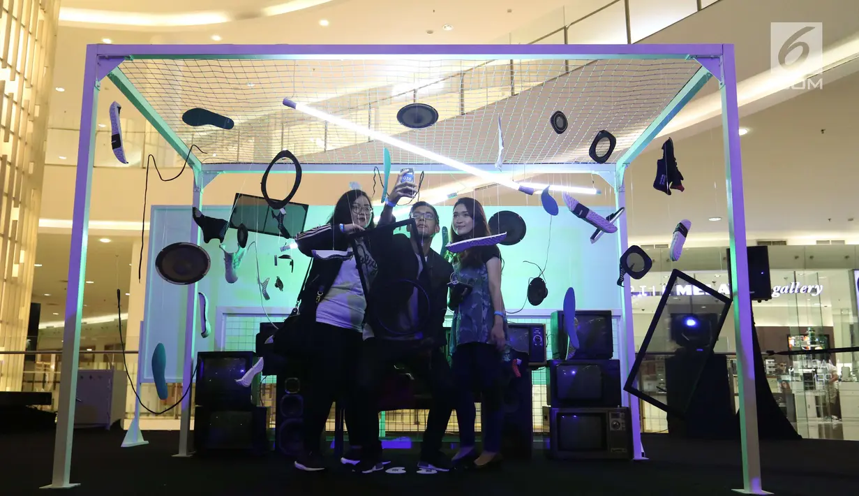 Pengunjung berswafoto di instalasi Adidas Original Is Never Finished di Senayan City, Jakarta, Rabu (28/2). Pameran instalasi seni mengkombinasikan personality adicolor, prophere dan EQT. (Liputan6.com/Angga Yuniar)