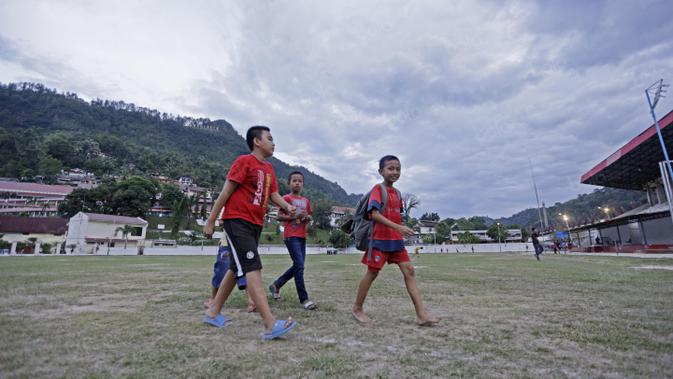 Anak-anak SSB PS TAL Sawahlunto berjalan pulang setelah mengikuti latihan di Stadion Tanah Lapang Ombilin, Sawahlunto, (8/11/2016). (Bola.com/Nicklas Hanoatubun)