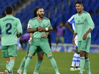 Pemain Real Madrid Karim Benzema melakukan selebrasi usai mencetak gol ke gawang Real Sociedad pada pertandingan La Liga di Stadion Anoeta, San Sebastian, Spanyol, Minggu (21/6/2020). Real Madrid memuncaki klasemen sementara La Liga usai mengalahkan Real Sociedad 2-1. (AP Photo/Alvaro Barrientos)