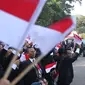 Pegawai Istana mengibarkan bendera merah putih saat rombongan mobil Presiden terpilih Joko Widodo (Jokowi)  melintas menuju gedung DPR di Istana Kepresidenan, Jakarta, Minggu (20/10/2019). Jokowi-Ma'ruf Amin kembali dilantik sebagai Presiden-Wapres RI periode 2019-2024. (Liputan6.com/Angga Yuniar)