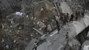 Warga melihat puing-puing bangunan yang hancur akibat serangan udara Israel di Kota Gaza, Palestina, (9/8). Tentara Israel kembali membombardir Gaza sebagai aksi balasan terhadap serangan militan Hamas. (AP Photo/Khalil Hamra)