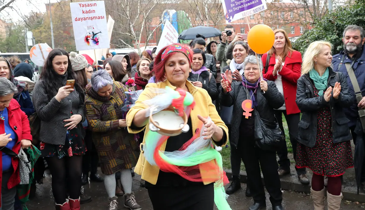 Seorang wanita bernyanyi dan menari saat berkumpul untuk memperingati Women's Day atau Hari Perempuan Internasional di Ankara, Turki, Kamis (8/3). (ADEM ALTAN/AFP)