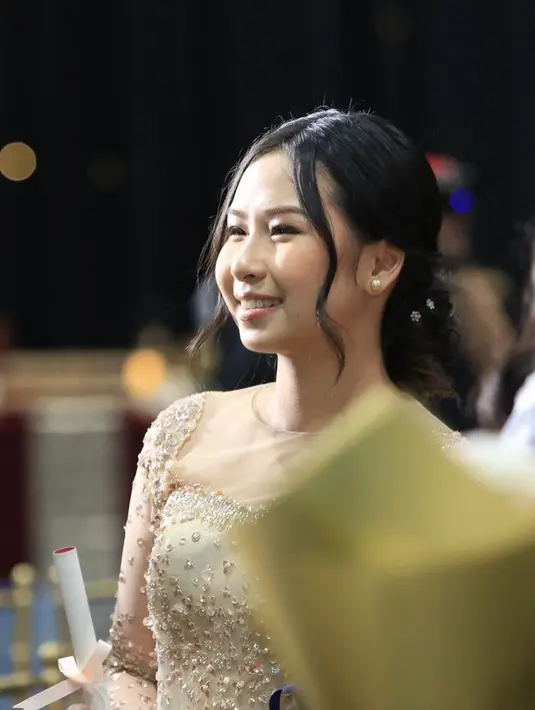 Rambut Aliyyah di sanggul updo modern dengan model belah dua di bagian depan rambut. Menyisakan dua helai poni yang membingkai wajah. Sanggulnya dihiasi dengan hairclip minimalis.  [@aliyyah.kohl]