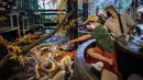 Pengunjung memberi makan ikan mas di restoran bertema ikan di Chiang Mai, Thailand, Selasa (12/4/2022). (Jack TAYLOR/AFP)