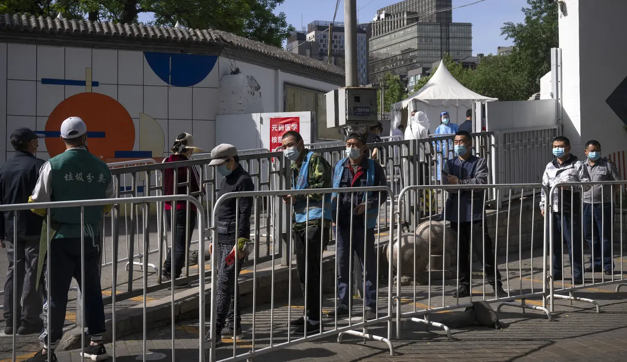 <p>Orang-orang mengantre untuk tes COVID-19 pada tempat pengujian setelah pihak berwenang memerintahkan putaran ketiga dari tiga tes COVID-19 berturut-turut untuk penduduk di Distrik Chaoyang, Beijing, China, Sabtu (7/5/2022). (AP Photo/Mark Schiefelbein)</p>