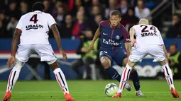 Gelandang PSG, Kylian Mbappe, berusaha melewati hadangan pemain Nice pada laga Ligue 1 Prancis di Stadion Parc des Princes, Paris, Jumat (27/10/2017). PSG menang 3-0 atas Nice. (AFP/Martin Bureau)